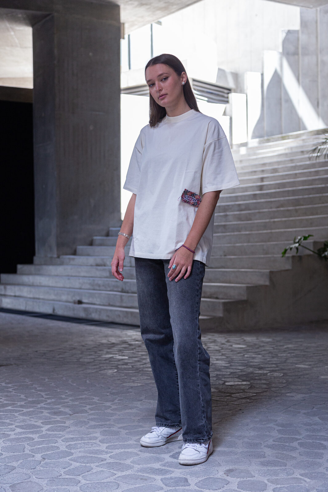 Model in oversized white BLEACH tee with woven side patch